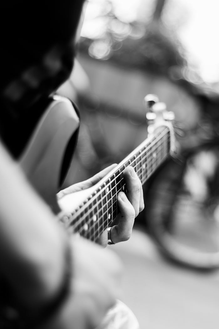 story-01 Close-up of a guitarists hands on the fretboard in black and white.